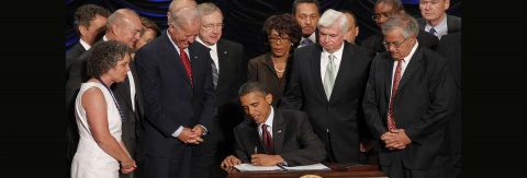 Obama Signing the Dodd Frank act surrounded by officials